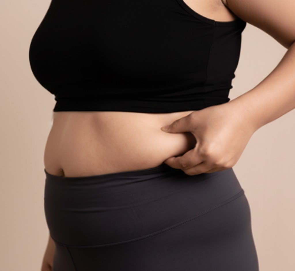 Person measuring waist showing wellness journey